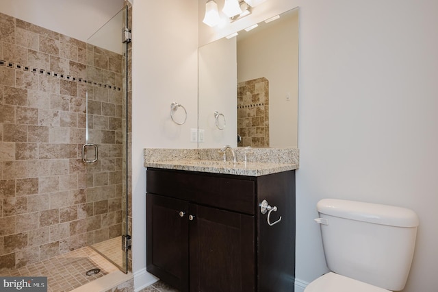 bathroom with vanity, a shower with shower door, and toilet