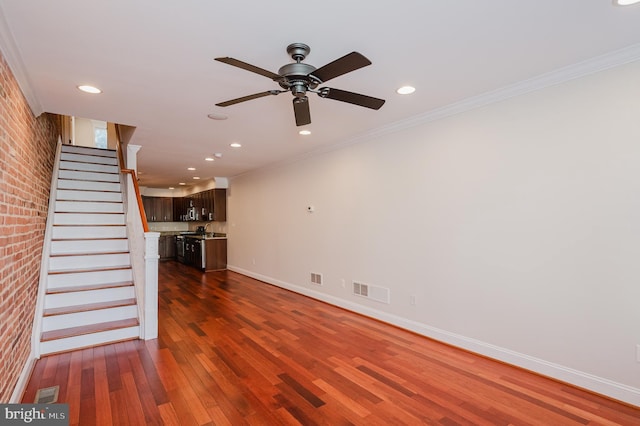 unfurnished living room featuring ornamental molding, brick wall, dark hardwood / wood-style floors, and ceiling fan