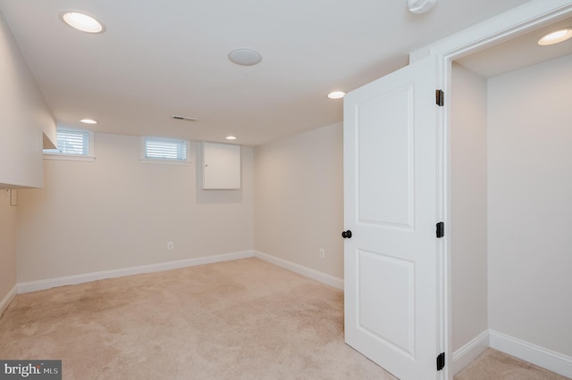 basement featuring light colored carpet and electric panel