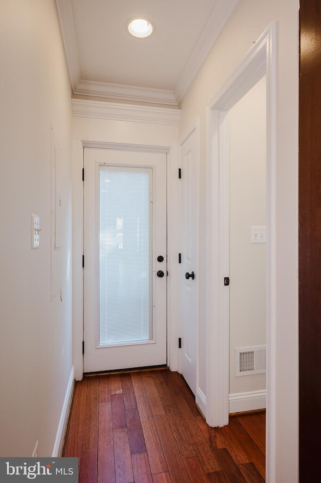 doorway with ornamental molding and dark hardwood / wood-style floors