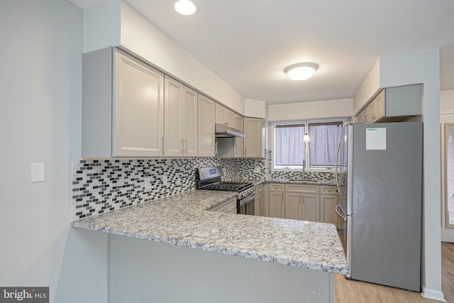 kitchen featuring kitchen peninsula, gray cabinets, stainless steel appliances, backsplash, and sink