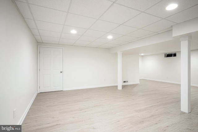 basement with a drop ceiling and light wood-type flooring