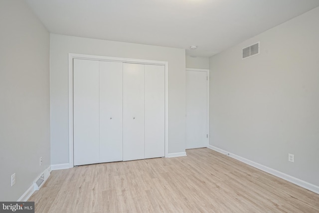 unfurnished bedroom featuring a closet and light hardwood / wood-style flooring