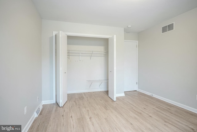 unfurnished bedroom with a closet and light hardwood / wood-style floors