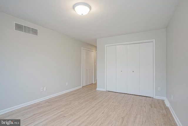 unfurnished bedroom featuring a closet and light hardwood / wood-style flooring