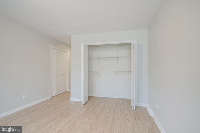 unfurnished bedroom featuring a closet and light wood-type flooring