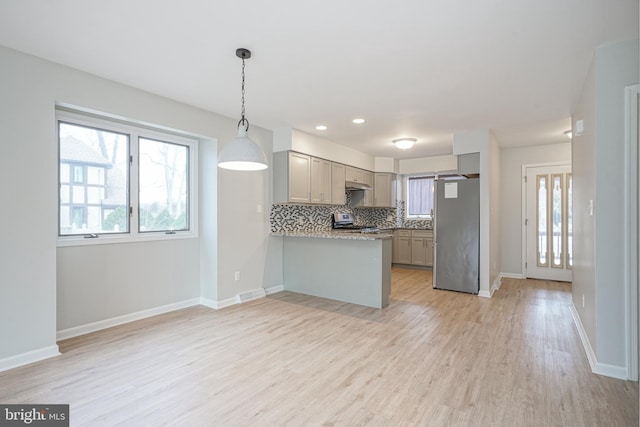 kitchen featuring appliances with stainless steel finishes, decorative light fixtures, backsplash, kitchen peninsula, and gray cabinetry