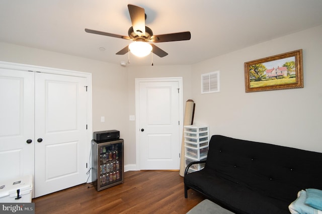 living area with dark hardwood / wood-style floors, beverage cooler, and ceiling fan