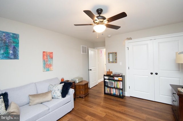 living room with dark hardwood / wood-style flooring and ceiling fan