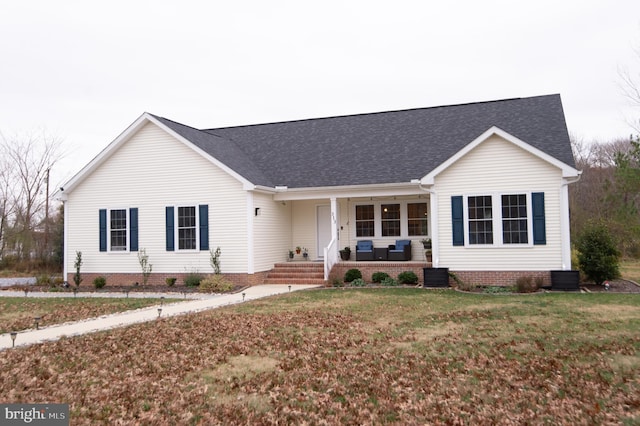 ranch-style home featuring a porch, central AC unit, and a front lawn