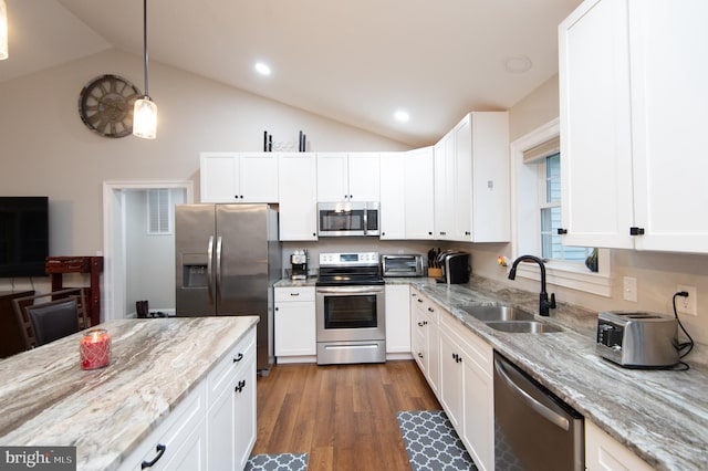 kitchen featuring pendant lighting, sink, stainless steel appliances, light stone counters, and white cabinets