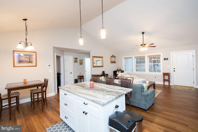 kitchen with dark wood-type flooring, decorative light fixtures, light stone countertops, and white cabinets