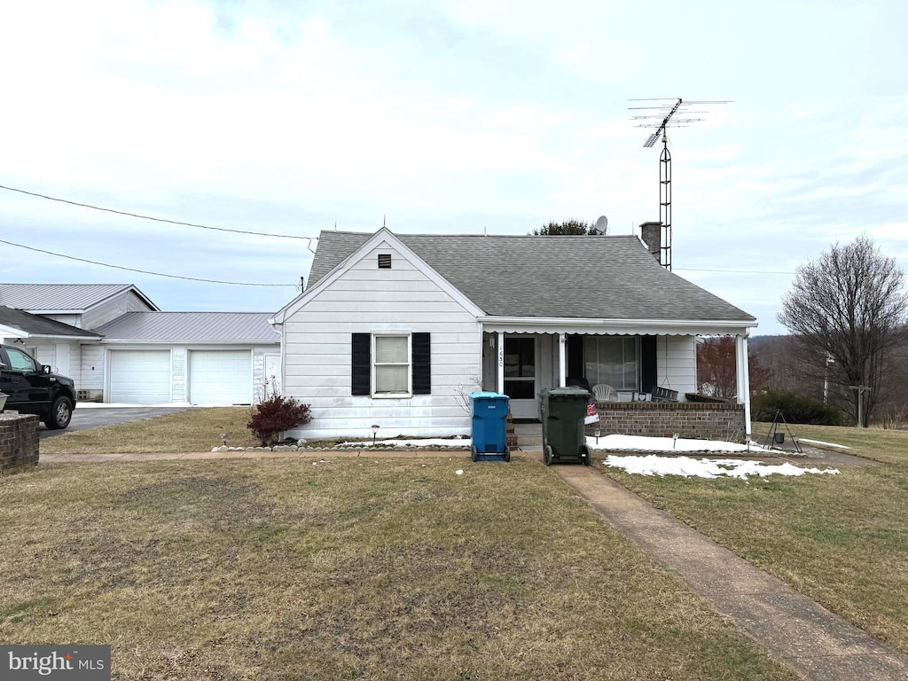 single story home with a garage, a front yard, and covered porch