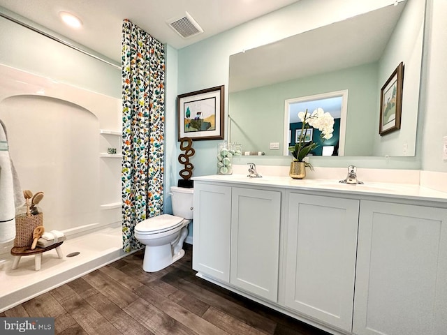 bathroom with toilet, walk in shower, hardwood / wood-style floors, and vanity