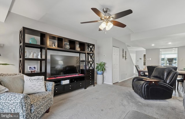 carpeted living room with ceiling fan