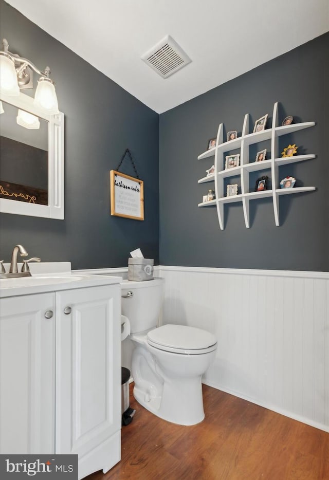 bathroom with wood-type flooring, toilet, and vanity