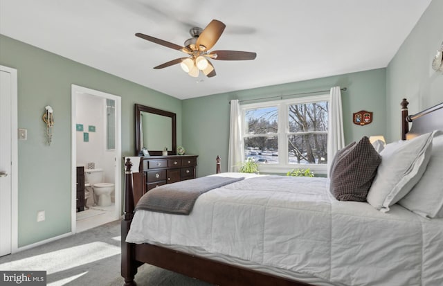 bedroom featuring ceiling fan, light carpet, and ensuite bath