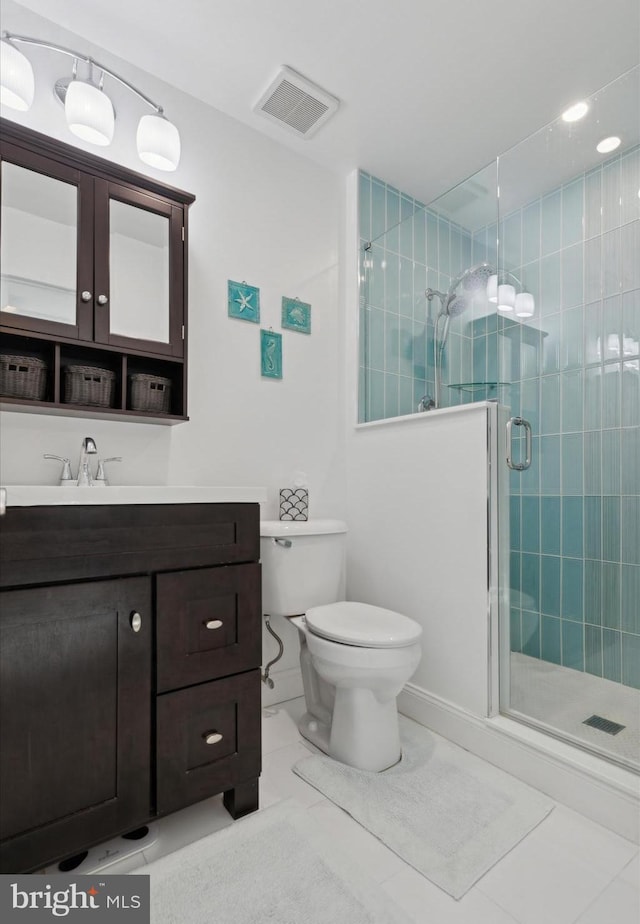 bathroom with toilet, vanity, tile patterned flooring, and a shower with door