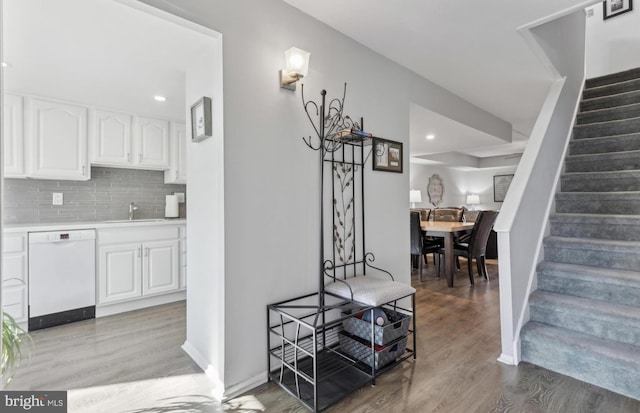 stairs featuring sink and hardwood / wood-style floors