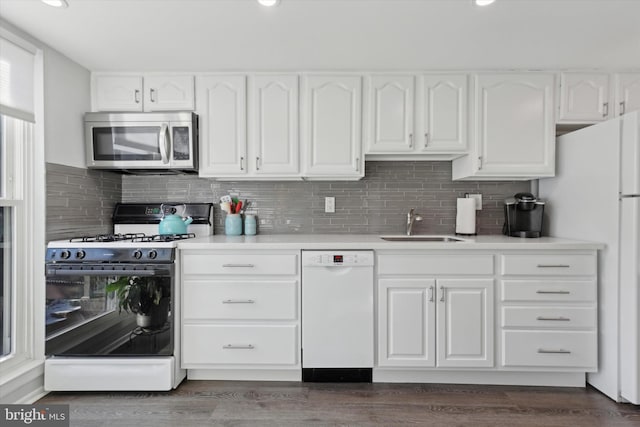 kitchen featuring dark hardwood / wood-style floors, decorative backsplash, sink, white appliances, and white cabinets