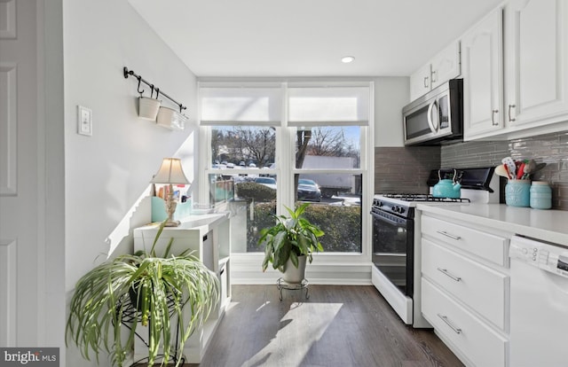 kitchen with tasteful backsplash, white cabinets, a wealth of natural light, and white appliances