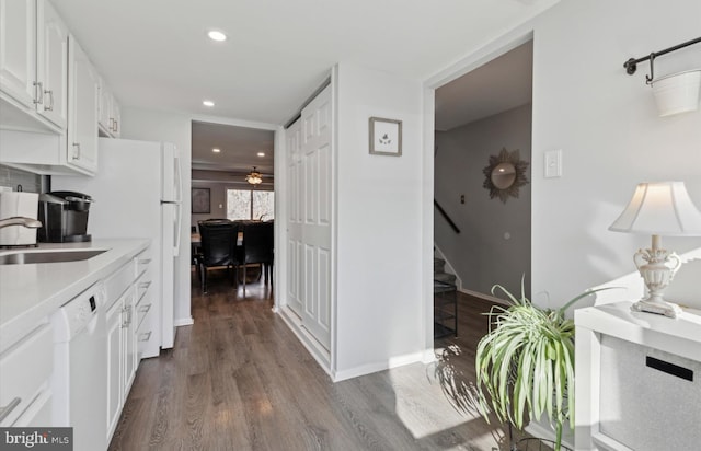 kitchen featuring ceiling fan, sink, white dishwasher, white cabinetry, and hardwood / wood-style flooring