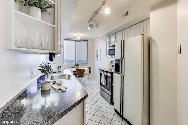 kitchen featuring white cabinets, sink, light tile patterned floors, and stainless steel appliances