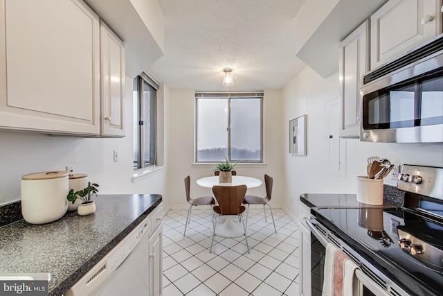 kitchen featuring a textured ceiling, appliances with stainless steel finishes, and white cabinets