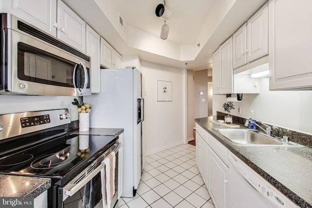 kitchen featuring white cabinets, sink, a tray ceiling, and stainless steel appliances