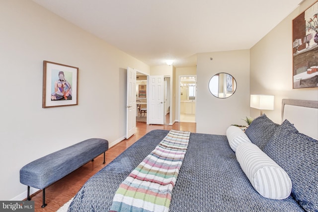 bedroom featuring wood-type flooring and ensuite bath