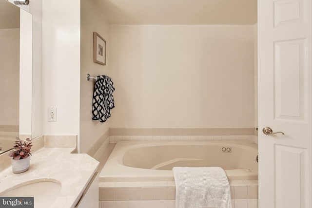 bathroom featuring vanity and tiled tub