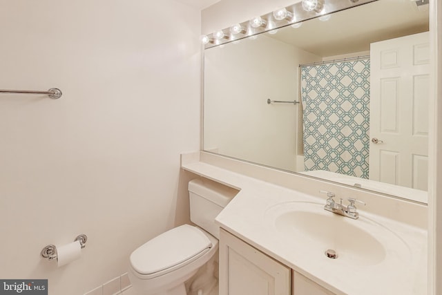 bathroom with toilet, vanity, and a shower with curtain