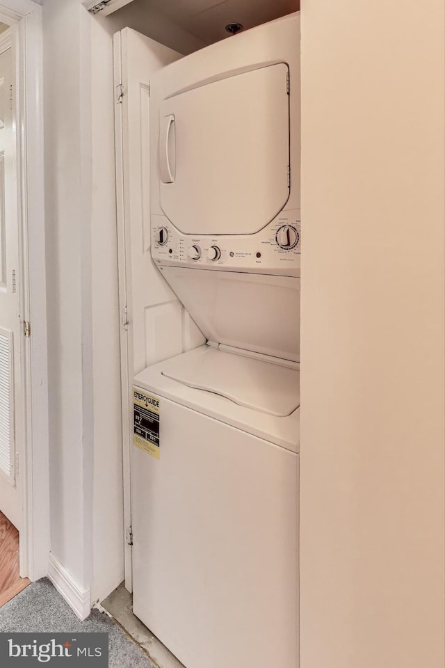 clothes washing area featuring stacked washer and clothes dryer