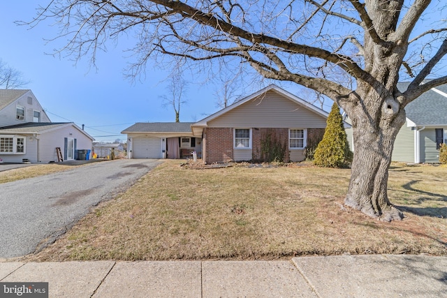 ranch-style house featuring a front lawn, brick siding, driveway, and an attached garage