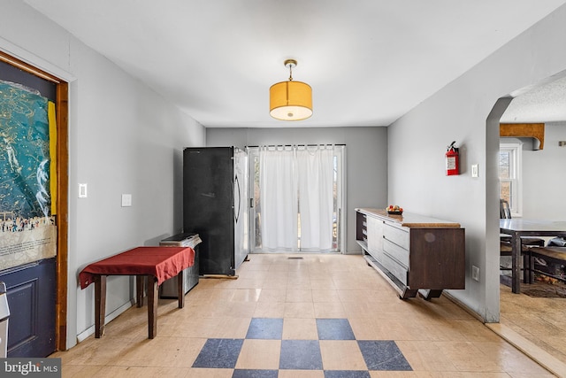 interior space featuring baseboards and arched walkways