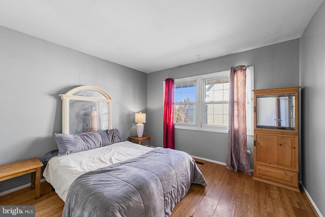 bedroom with baseboards and hardwood / wood-style floors