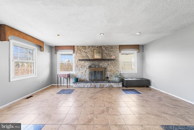 unfurnished living room featuring visible vents, a fireplace, baseboards, and tile patterned floors