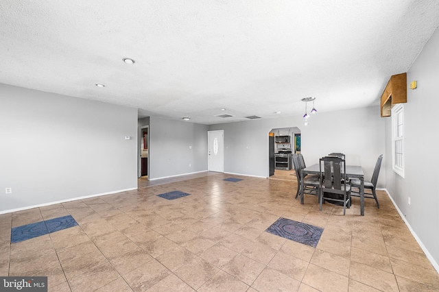 dining room with a textured ceiling and baseboards