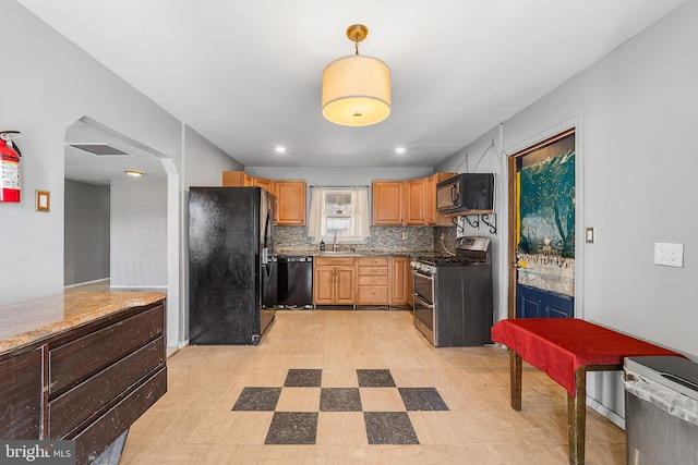 kitchen featuring decorative light fixtures, light floors, backsplash, a sink, and black appliances