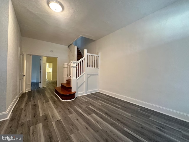 staircase with a textured ceiling and hardwood / wood-style flooring