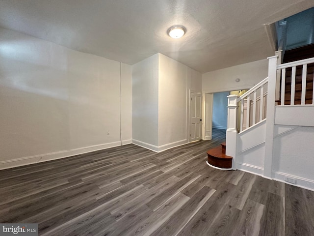 spare room with dark hardwood / wood-style floors and a textured ceiling