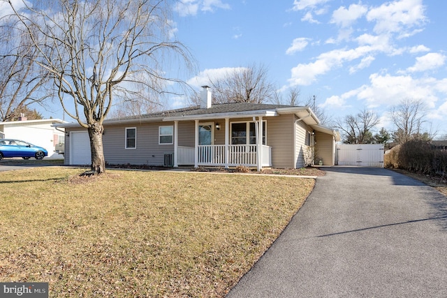 single story home featuring a gate, covered porch, a front yard, a garage, and a chimney