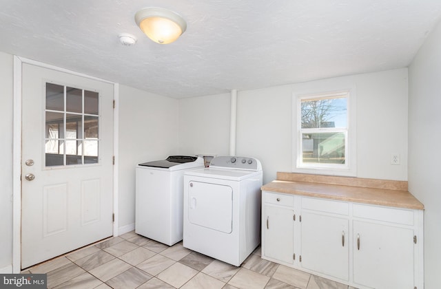 washroom featuring cabinet space, a textured ceiling, and separate washer and dryer