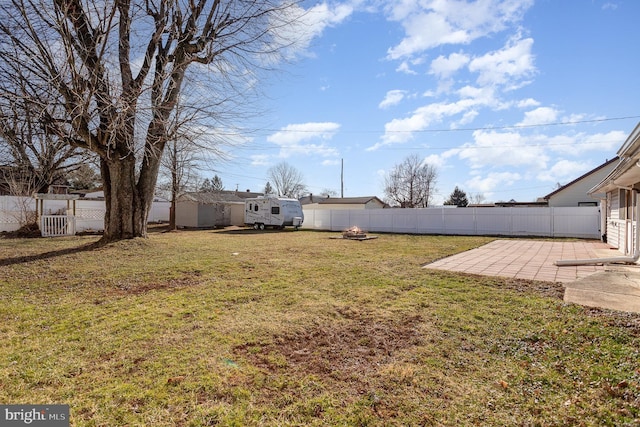 view of yard with a fire pit, a patio, an outdoor structure, and a fenced backyard