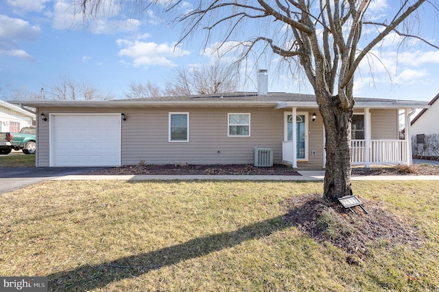 ranch-style house featuring aphalt driveway, an attached garage, central AC unit, and a front yard