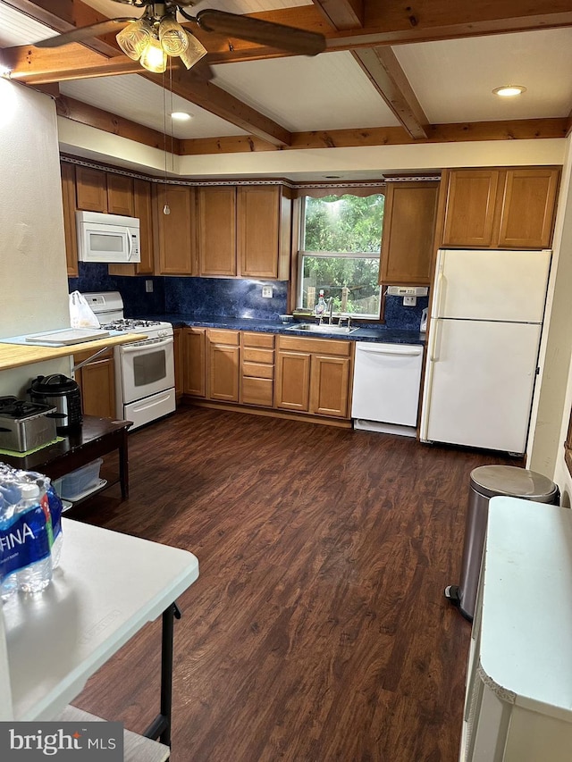 kitchen featuring ceiling fan, dark hardwood / wood-style floors, sink, white appliances, and beamed ceiling