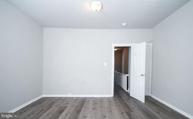 unfurnished room featuring dark wood-type flooring