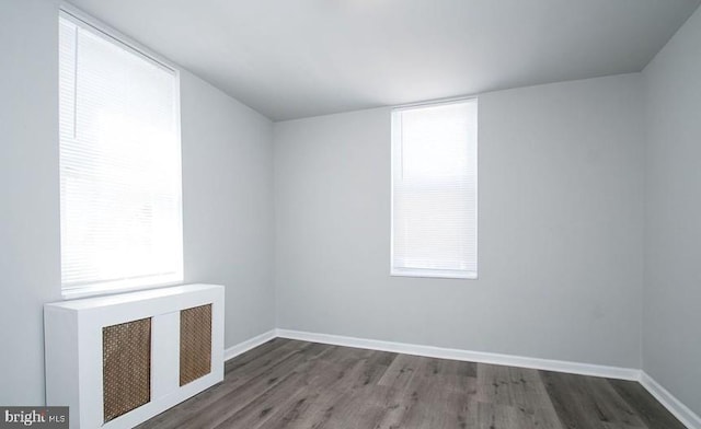 empty room with dark hardwood / wood-style flooring