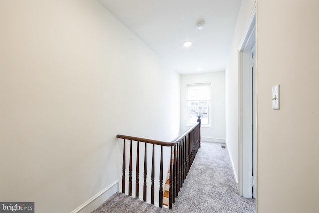 hall with light colored carpet