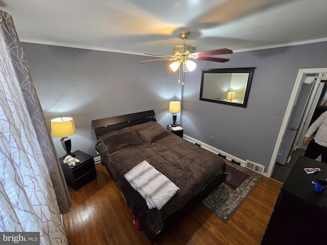 bedroom featuring dark hardwood / wood-style floors, ceiling fan, and ornamental molding